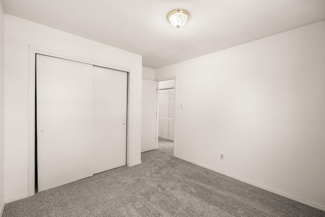 1905 Gomez Dr SW, Los Lunas, NM 87031 - unfurnished bedroom with carpet, a closet, a textured ceiling, and baseboards