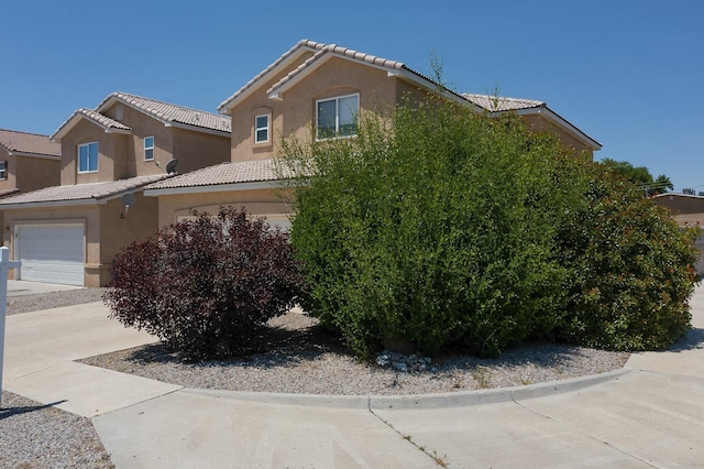1723 Avenida Real, Albuquerque, NM 87105 - view of property exterior featuring stucco siding, a tile roof, a garage, and driveway