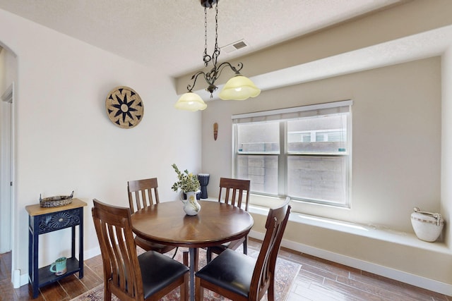 1723 Avenida Real, Albuquerque, NM 87105 - dining area featuring wood finished floors, baseboards, a textured ceiling, and arched walkways