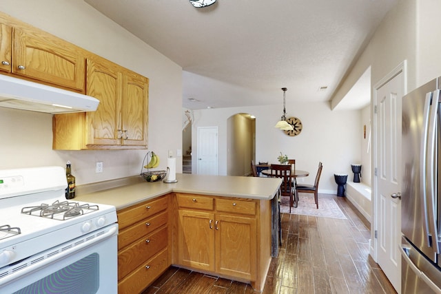 1723 Avenida Real, Albuquerque, NM 87105 - kitchen featuring white gas stove, under cabinet range hood, freestanding refrigerator, arched walkways, and a peninsula
