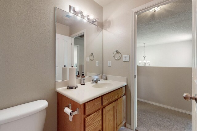 1723 Avenida Real, Albuquerque, NM 87105 - half bathroom with toilet, vanity, a chandelier, and a textured ceiling