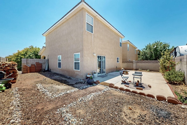 1723 Avenida Real, Albuquerque, NM 87105 - rear view of house with stucco siding, a fenced backyard, and a patio