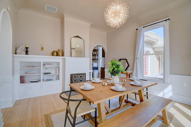 223 14th St NW, Albuquerque, NM 87104 - dining room featuring a chandelier, hardwood / wood-style flooring, and arched walkways