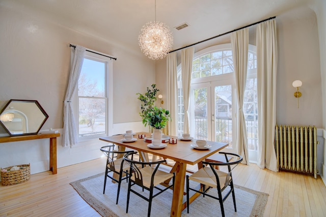 223 14th St NW, Albuquerque, NM 87104 - dining room featuring radiator heating unit, a chandelier, and light wood finished floors