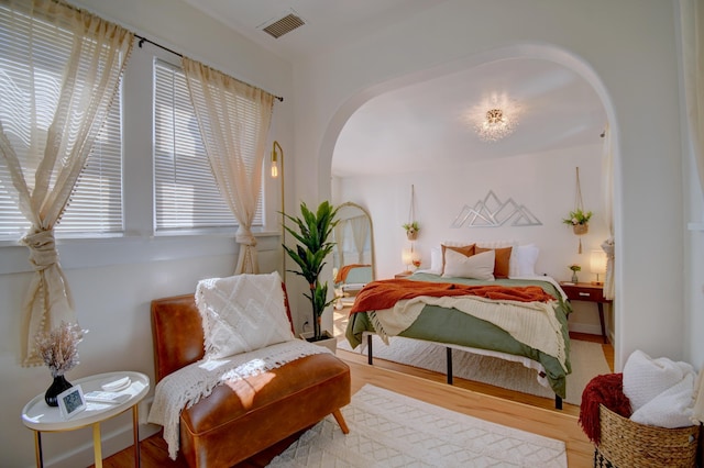 223 14th St NW, Albuquerque, NM 87104 - bedroom with arched walkways, multiple windows, and wood finished floors