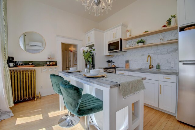 223 14th St NW, Albuquerque, NM 87104 - kitchen featuring radiator, appliances with stainless steel finishes, a sink, open shelves, and a chandelier