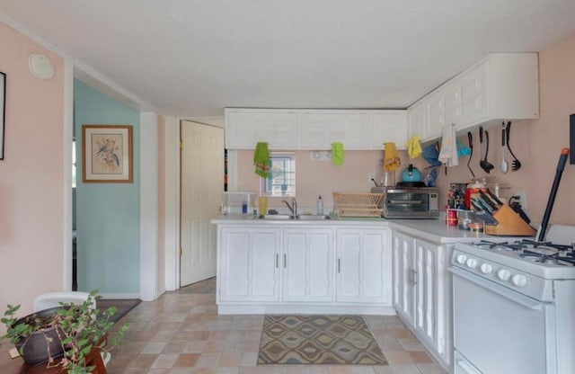 223 14th St NW, Albuquerque, NM 87104 - kitchen featuring white gas stove, a sink, white cabinetry, light countertops, and baseboards