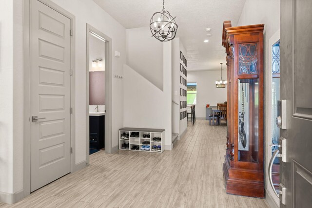 1661 Camino Culiacan, Los Lunas, NM 87031 - entryway with a chandelier, light wood-style flooring, and baseboards