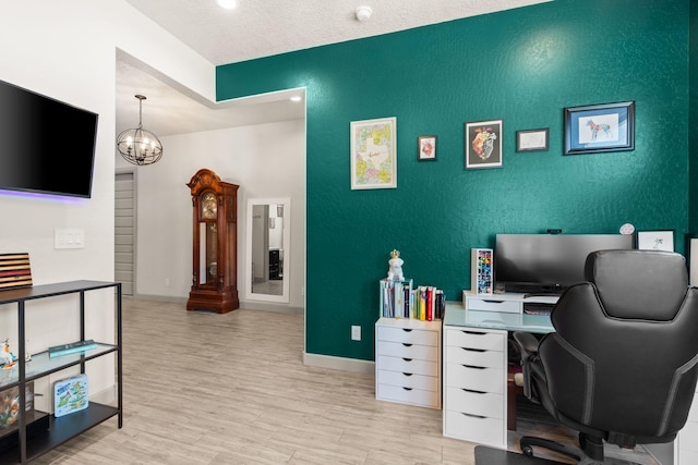 1661 Camino Culiacan, Los Lunas, NM 87031 - office area featuring light wood-style floors, baseboards, an accent wall, and a chandelier