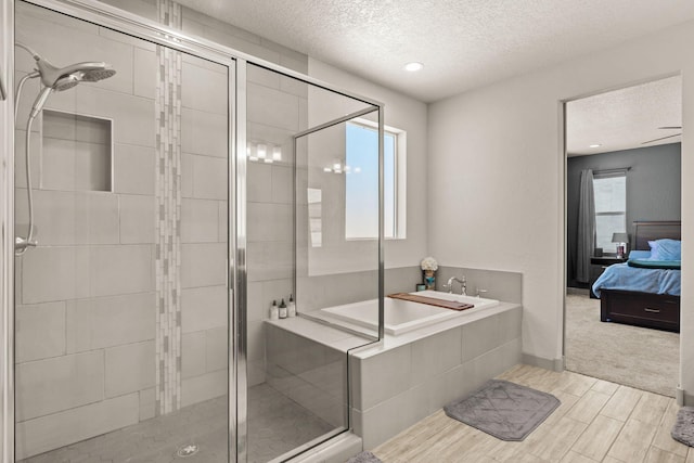1661 Camino Culiacan, Los Lunas, NM 87031 - full bathroom featuring a textured ceiling, a shower stall, a garden tub, ensuite bathroom, and wood finished floors