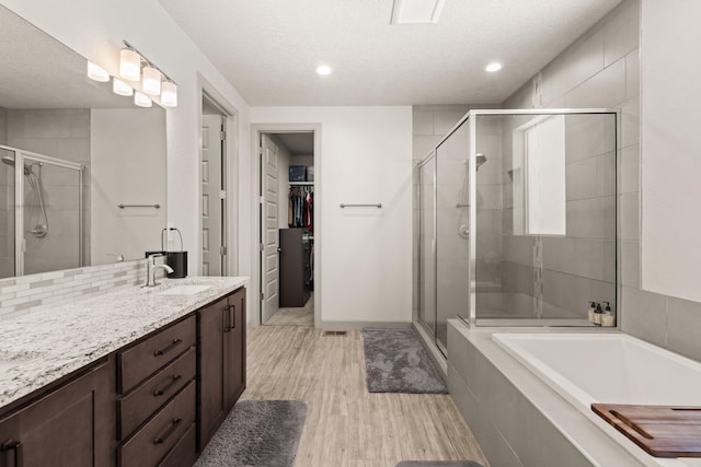 1661 Camino Culiacan, Los Lunas, NM 87031 - full bath with a stall shower, vanity, a textured ceiling, wood finished floors, and a walk in closet