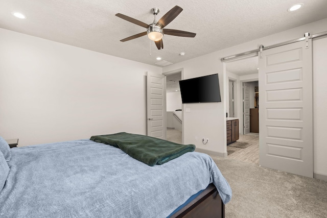 1661 Camino Culiacan, Los Lunas, NM 87031 - bedroom featuring a barn door, recessed lighting, a textured ceiling, light carpet, and ceiling fan
