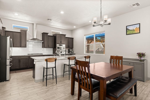 1661 Camino Culiacan, Los Lunas, NM 87031 - dining space featuring light wood finished floors, a chandelier, healthy amount of natural light, a textured ceiling, and recessed lighting