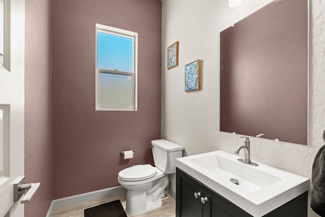 1661 Camino Culiacan, Los Lunas, NM 87031 - bathroom featuring wood finished floors, toilet, vanity, baseboards, and a textured wall