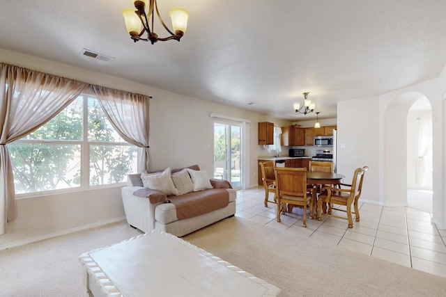 525 Peaceful Meadows Dr NE, Rio Rancho, NM 87144 - living area featuring a chandelier, arched walkways, baseboards, and light tile patterned flooring
