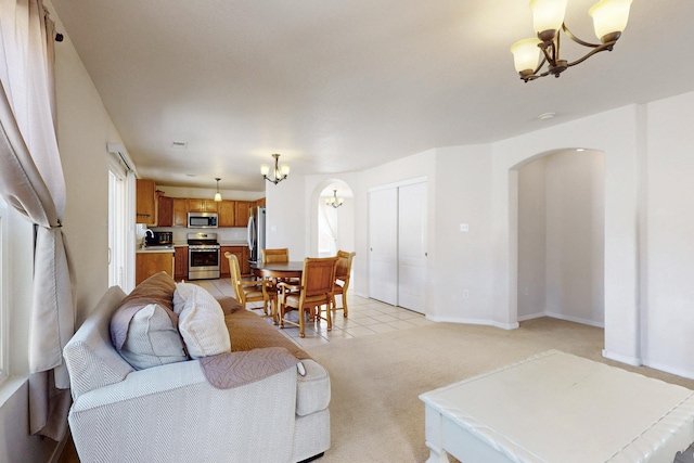 525 Peaceful Meadows Dr NE, Rio Rancho, NM 87144 - living room with a chandelier, arched walkways, plenty of natural light, and light carpet