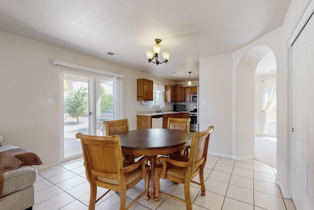 525 Peaceful Meadows Dr NE, Rio Rancho, NM 87144 - dining room with a chandelier, light tile patterned floors, arched walkways, and baseboards