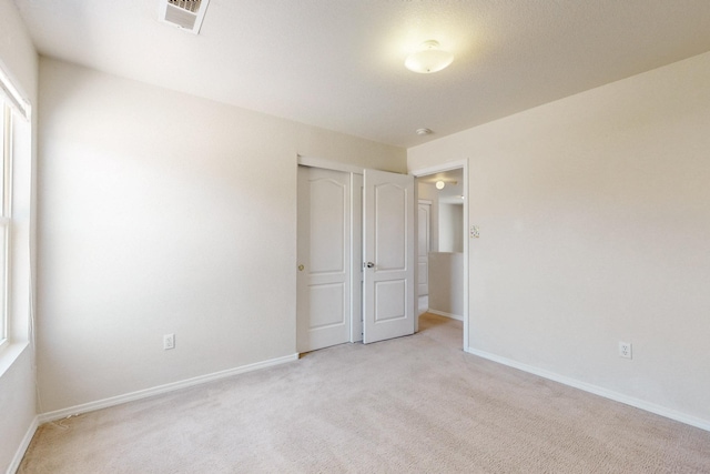525 Peaceful Meadows Dr NE, Rio Rancho, NM 87144 - unfurnished bedroom with light colored carpet, baseboards, and a closet
