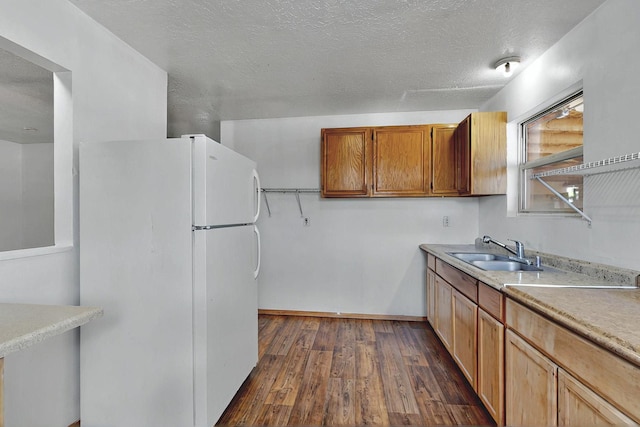 1237 Gabaldon Rd, Belen, NM 87002 - kitchen with freestanding refrigerator, a sink, dark wood-type flooring, light countertops, and a textured ceiling