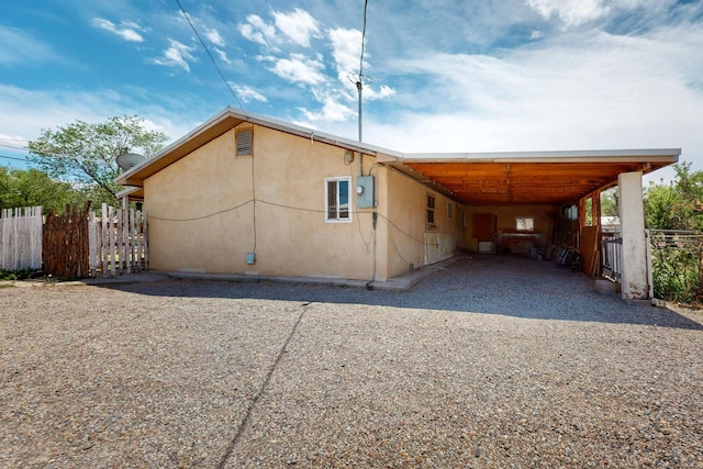 1237 Gabaldon Rd, Belen, NM 87002 - view of property exterior with gravel driveway, an attached carport, and stucco siding