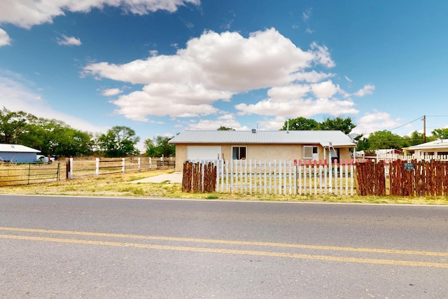 1237 Gabaldon Rd, Belen, NM 87002 - single story home with a fenced front yard, stucco siding, and metal roof