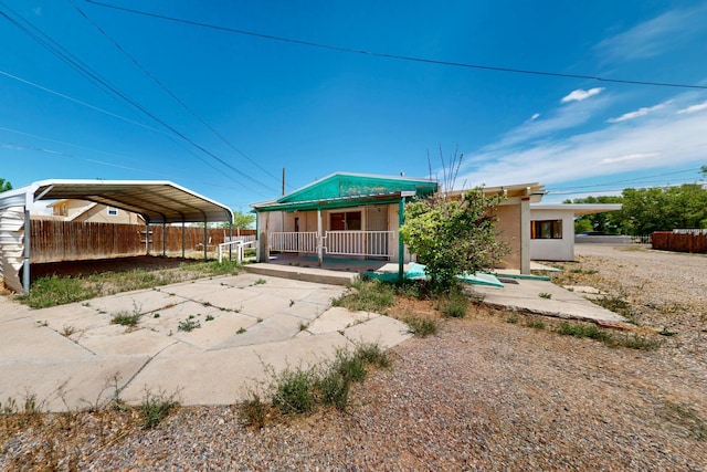1237 Gabaldon Rd, Belen, NM 87002 - back of property featuring covered porch, driveway, a carport, and stucco siding
