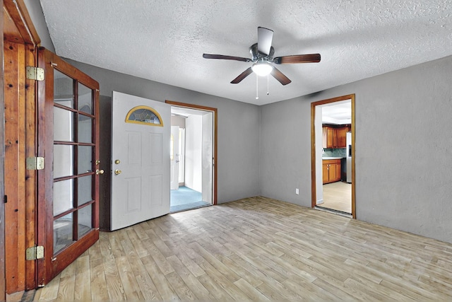 1237 Gabaldon Rd, Belen, NM 87002 - foyer featuring light wood-type flooring, a textured ceiling, and ceiling fan