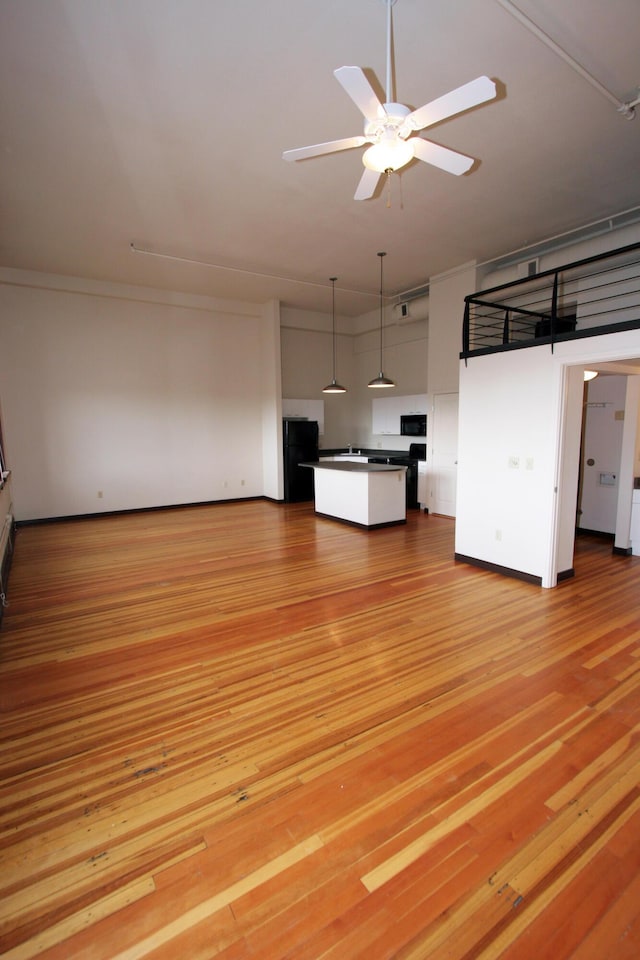 301 Central Ave NE Unit 202, Albuquerque, NM 87102 - unfurnished living room featuring a ceiling fan and light wood-style floors