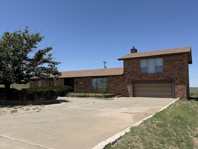 2833 Tiffany Rd, Tucumcari, NM 88401 - view of front facade featuring an attached garage, brick siding, concrete driveway, a chimney, and roof with shingles