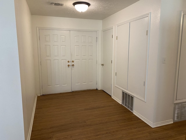 2833 Tiffany Rd, Tucumcari, NM 88401 - hallway featuring dark wood-style flooring, a textured ceiling, and baseboards