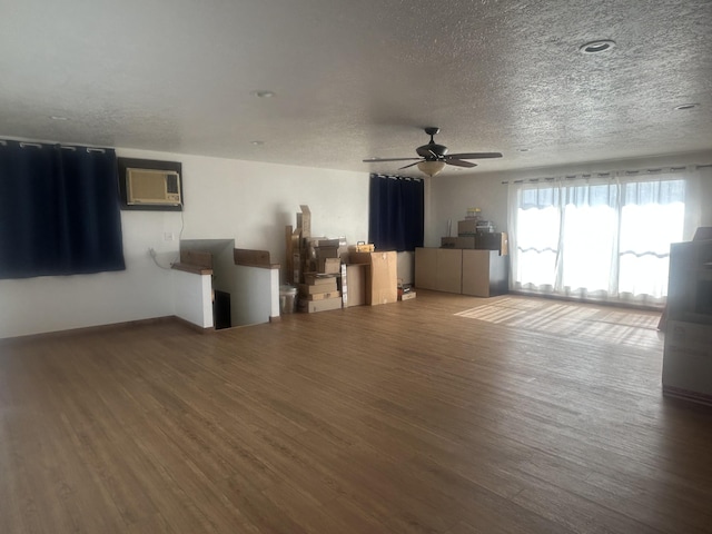 2833 Tiffany Rd, Tucumcari, NM 88401 - living room featuring wood finished floors, a textured ceiling, a ceiling fan, and an AC wall unit