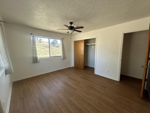 2833 Tiffany Rd, Tucumcari, NM 88401 - unfurnished bedroom featuring dark wood-style floors, a closet, a textured ceiling, baseboards, and a ceiling fan