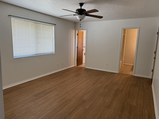 2833 Tiffany Rd, Tucumcari, NM 88401 - empty room featuring a ceiling fan, dark wood finished floors, a textured ceiling, and baseboards
