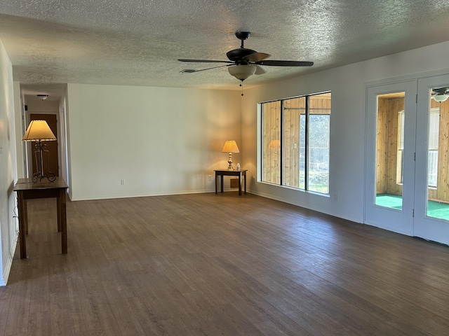 2833 Tiffany Rd, Tucumcari, NM 88401 - unfurnished living room featuring a ceiling fan, dark wood-type flooring, a textured ceiling, and baseboards