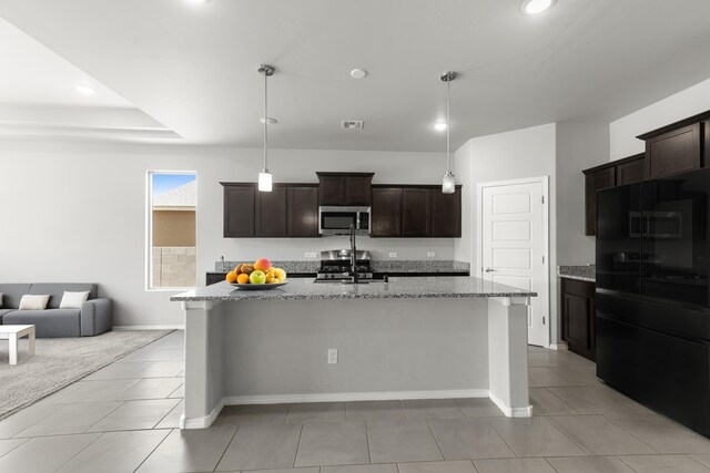 6 Margarita Cir, Los Lunas, NM 87031 - kitchen with appliances with stainless steel finishes, light stone countertops, dark brown cabinetry, light tile patterned floors, and recessed lighting