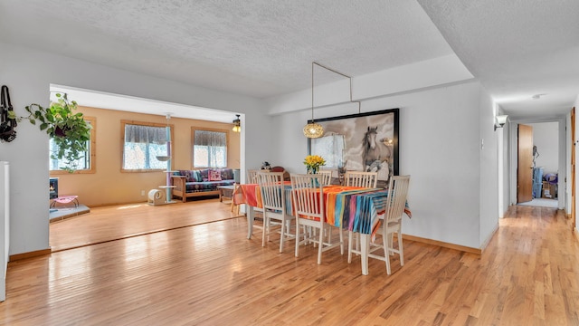 84 Fire Station Rd, Los Lunas, NM 87031 - dining space featuring wood finished floors, a textured ceiling, and baseboards