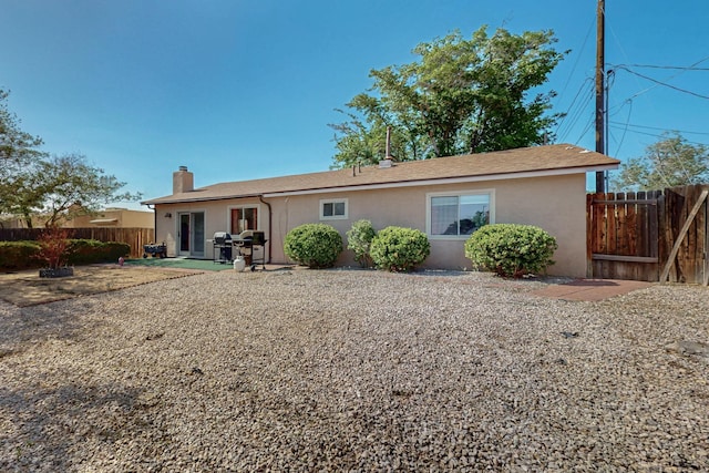 8224 Bret Pl NE, Albuquerque, NM 87109 - rear view of property featuring stucco siding, a chimney, and a patio area
