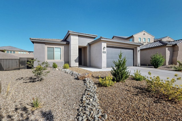 1605 Copper Mountain Trl NW, Albuquerque, NM 87120 - view of front of house with stucco siding, a garage, and concrete driveway