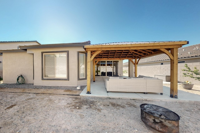 1605 Copper Mountain Trl NW, Albuquerque, NM 87120 - back of house with a patio area, an outdoor living space with a fire pit, a gazebo, metal roof, and stucco siding