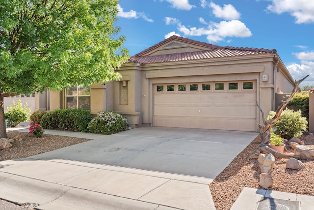 3827 Fox Sparrow Trl NW, Albuquerque, NM 87120 - view of front facade featuring driveway, an attached garage, stucco siding, and a tiled roof