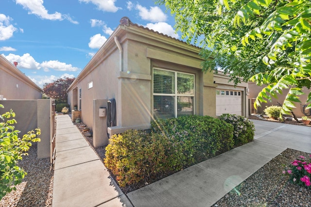 3827 Fox Sparrow Trl NW, Albuquerque, NM 87120 - view of side of home with stucco siding, a garage, concrete driveway, and a tile roof