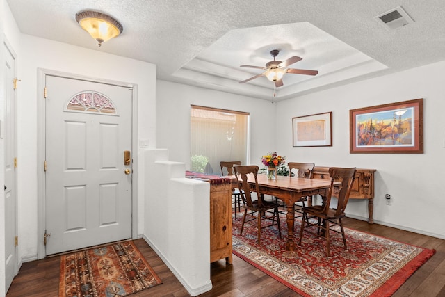 3827 Fox Sparrow Trl NW, Albuquerque, NM 87120 - dining room with a raised ceiling, dark wood-type flooring, a textured ceiling, and a ceiling fan
