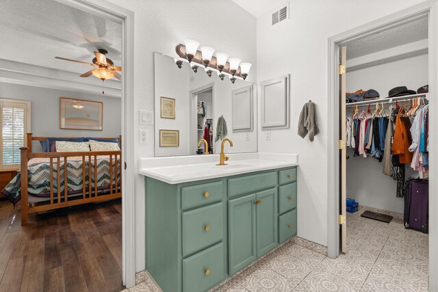 3827 Fox Sparrow Trl NW, Albuquerque, NM 87120 - bathroom with ceiling fan, vanity, a textured ceiling, a spacious closet, and ensuite bath