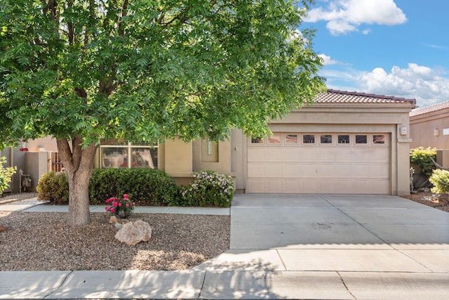 3827 Fox Sparrow Trl NW, Albuquerque, NM 87120 - view of front of house with stucco siding, concrete driveway, an attached garage, and a tile roof