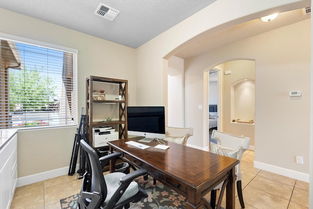 2659 Vista Manzano Loop NE, Rio Rancho, NM 87144 - home office featuring arched walkways, baseboards, light tile patterned floors, and a textured ceiling