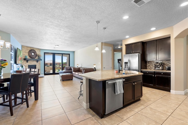 2659 Vista Manzano Loop NE, Rio Rancho, NM 87144 - kitchen with a sink, appliances with stainless steel finishes, light tile patterned floors, a textured ceiling, and decorative backsplash