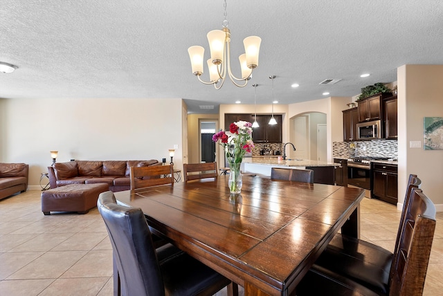 2659 Vista Manzano Loop NE, Rio Rancho, NM 87144 - dining room with light tile patterned floors, a textured ceiling, arched walkways, a chandelier, and recessed lighting
