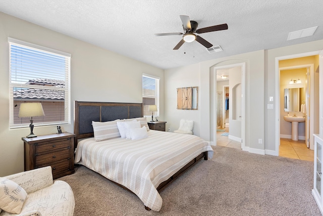 2659 Vista Manzano Loop NE, Rio Rancho, NM 87144 - bedroom featuring a sink, light colored carpet, light tile patterned floors, ensuite bathroom, and a textured ceiling