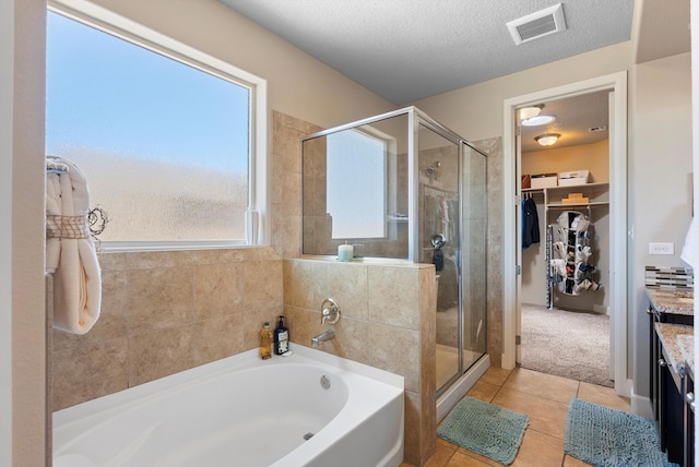 2659 Vista Manzano Loop NE, Rio Rancho, NM 87144 - full bath with a garden tub, a stall shower, tile patterned flooring, a walk in closet, and a textured ceiling