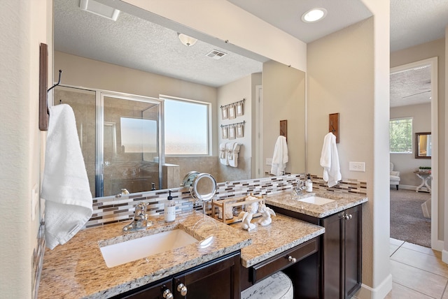 2659 Vista Manzano Loop NE, Rio Rancho, NM 87144 - full bath featuring tile patterned floors, vanity, a stall shower, decorative backsplash, and a textured ceiling